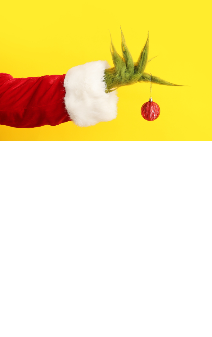 Grinch hand holding ornament on yellow background